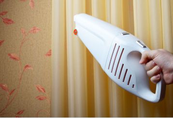 Person cleaning wooden blinds with a soft cloth.