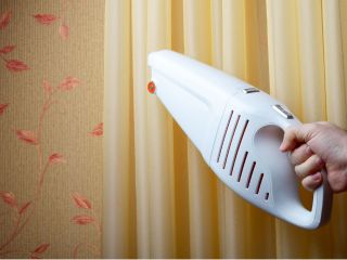 How to clean blinds and other window coverings? | Master Blinds & Shades CA Person cleaning wooden blinds with a soft cloth.