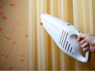 Person cleaning wooden blinds with a soft cloth.