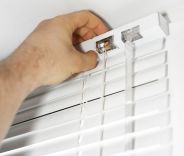 A male installing Venetian blinds